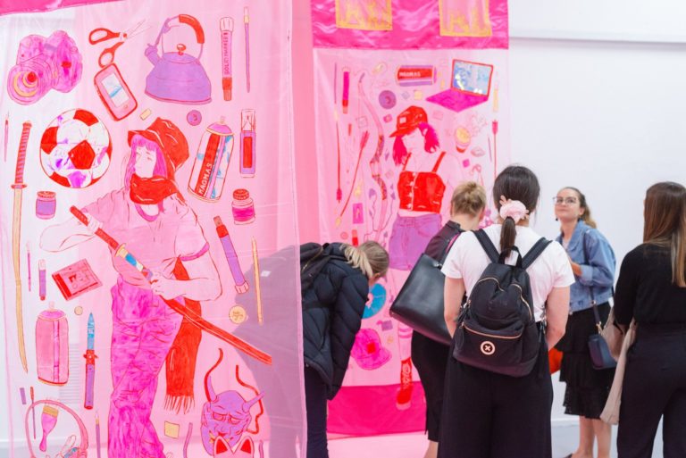 Group of women looking at a pink work of art in gallery